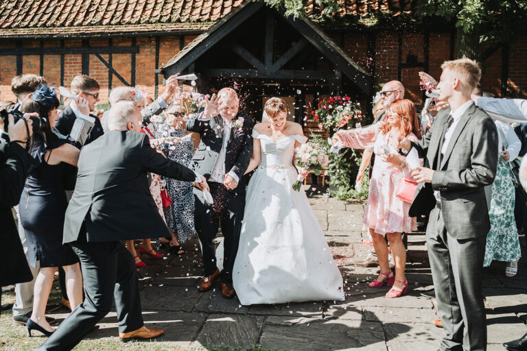Newly wed couple showered with confetti outside the Tithe Barn, Bedford